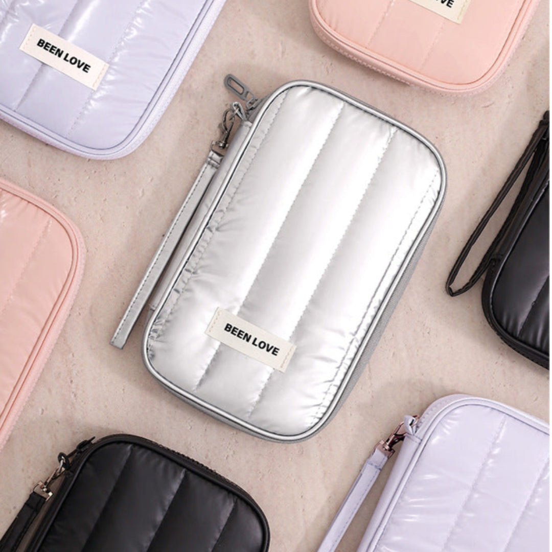 Collection of 'BEEN LOVE' branded pouches in various colors on a neutral background.