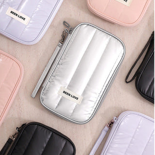 Collection of 'BEEN LOVE' branded pouches in various colors on a neutral background.