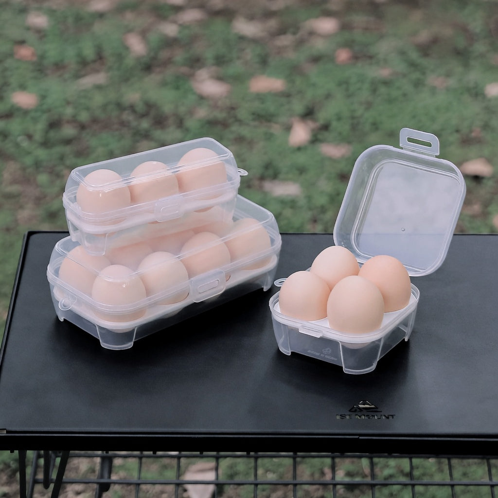 Clear plastic egg containers with eggs on a black surface outdoors.